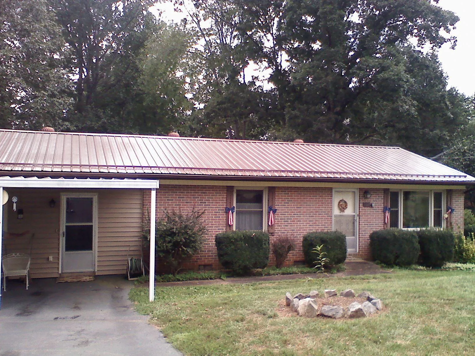 Bronze metal roof and carport on a brick ranch home — Roof Repair work by our crew in Defiance